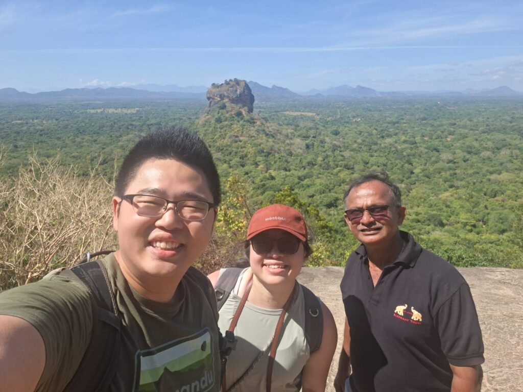 Travelers and their driver overlooking Sigiriya rock from Pidurangala, Sri Lanka